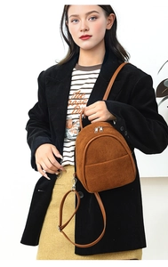 Brown corduroy mini backpack shown as crossbody bag on model with modern styling