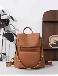 Detail view of brown PU leather anti-theft backpack with side pockets and smooth zipper