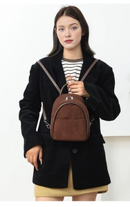 Detail view of brown corduroy mini backpack featuring vintage texture and zipper compartments
