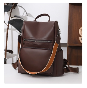 Detail of dark brown lychee leather texture and colorful detachable woven shoulder strap