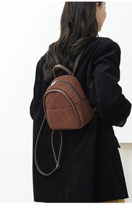 Detail of brown corduroy mini backpack with faux leather trim and zipper closure