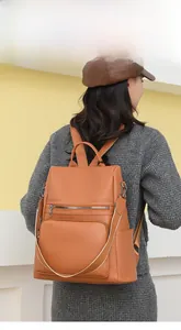 Detail showing the brown lychee pattern leather backpack with anti-theft zipper pockets