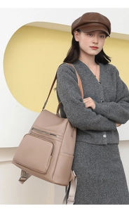 Close-up of stylish taupe PU leather backpack with荔枝纹 grain texture and fabric straps