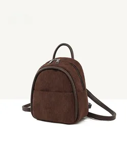 Detail view of coffee corduroy mini backpack showing side thickness and fabric texture
