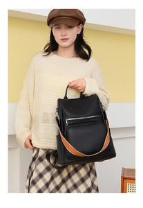 Close-up of black PU leather backpack with荔枝 pattern and striped shoulder strap