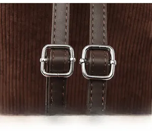 Detail of adjustable shoulder straps with silver buckles on corduroy backpack