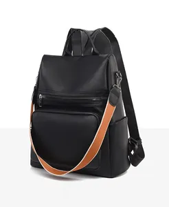 Detail of black PU leather anti-theft backpack with orange woven shoulder strap