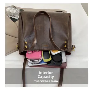 Interior view of large brown tote bag showing capacity for phone, wallet and notebook