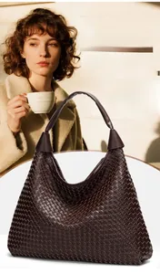Dettaglio della trama in pelle intrecciata marrone scuro su una capiente borsa tote
