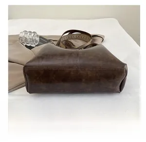 Detail view showing durable double-stitched base of dark brown retro leather handbag