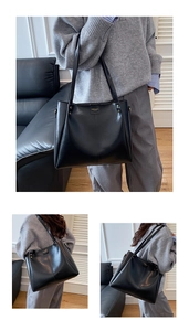 Detail of matte black leather tote bag featuring gold logo and double shoulder straps