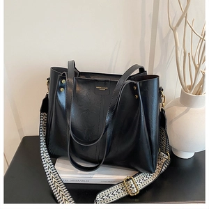 Detail of black leather tote bag featuring a bohemian geometric pattern wide strap
