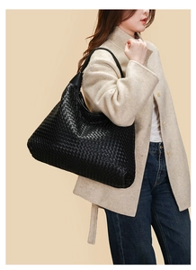 Dettaglio della trama della borsa tote in pelle intrecciata nera con tracolla larga