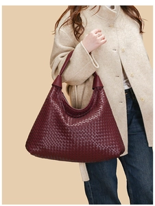 Dettaglio della borsa tote in pelle intrecciata bordeaux mostrata su modella