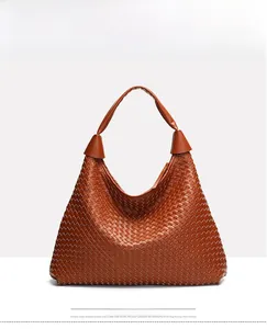 Dettaglio della borsa hobo intrecciata marrone caramello con tracolla larga e metallo