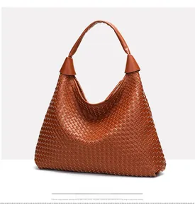 Dettaglio della trama in pelle intrecciata marrone su una grande borsa hobo minimalista
