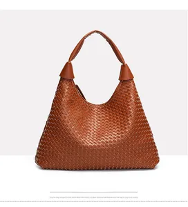 Dettaglio della borsa tote in pelle PU intrecciata caramello con motivo intrecciato