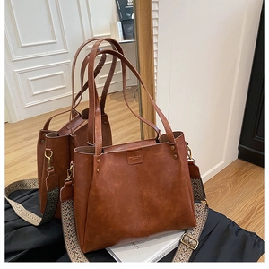 Brown vintage leather tote featuring an ethnic geometric patterned wide strap and engraving