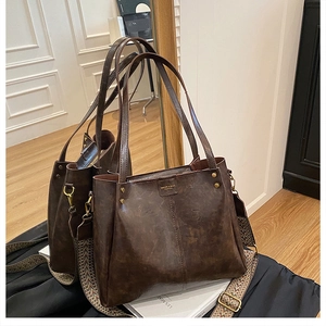 Detail of vintage brown tote bag showing wide ethnic style strap and brand logo