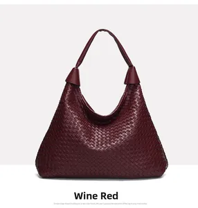 Dettaglio della borsa hobo intrecciata bordeaux con forma a triangolo e manico in pelle