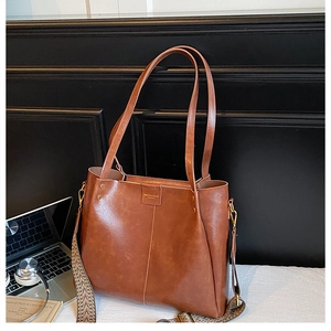 Detail of caramel leather tote bag with vintage geometric woven wide shoulder strap