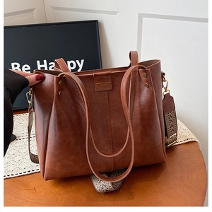 Detail of vintage brown tote bag with colorful geometric woven wide shoulder strap