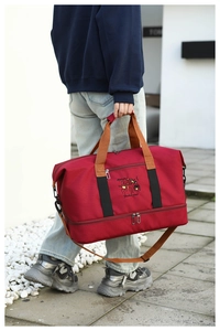 Outdoor shot of red travel bag featuring shoe compartment and yellow dance embroidery
