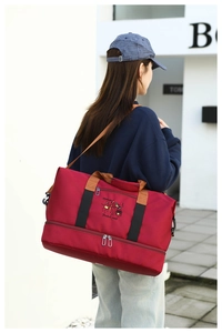Detail of burgundy sports bag showing bottom shoe compartment and Fashion Trend embroidery