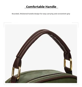 Detail of reinforced round leather handle with gold hardware on green textured tote