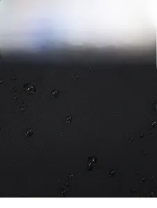 Close-up of waterproof black nylon fabric showing water droplets on the surface