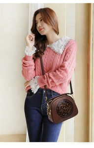Detailed view of brown embossed leather shoulder bag with ornate vintage round medallion