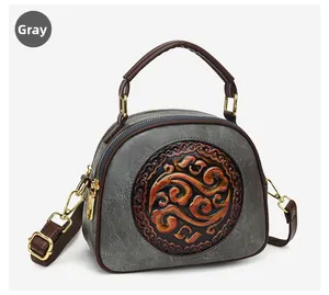Detail of grey embossed leather shoulder bag with traditional Chinese cloud patterns