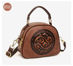 Detail of yellow-brown textured leather bag featuring a round vintage floral embossing