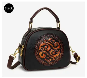 Detail of vintage black shoulder bag with orange embossed relief pattern on matte leather