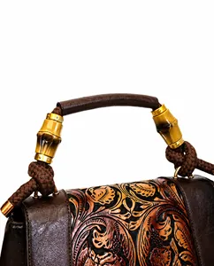 Detailed close-up of retro floral embossed leather bag with bamboo style handle buckle