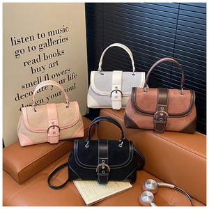 Detail of vintage patchwork handbags featuring suede leather and metal horseshoe buckles