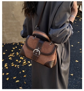 Detailed view of vintage patchwork leather bag with silver buckle on autumn leaves background
