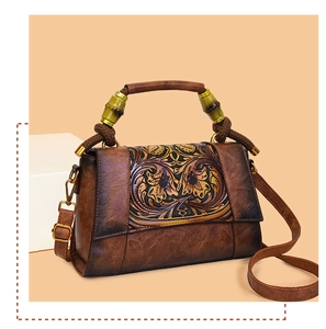 Detail of vintage brown embossed leather bag with unique bamboo style handle and metal hooks