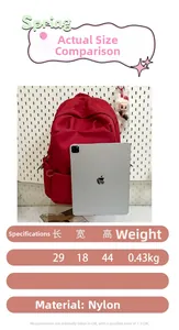 Detail view of the red nylon backpack showing 29x18x44cm dimensions and 0.43kg lightweight