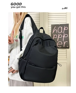 Side view of a large capacity black nylon backpack for students shown on a model