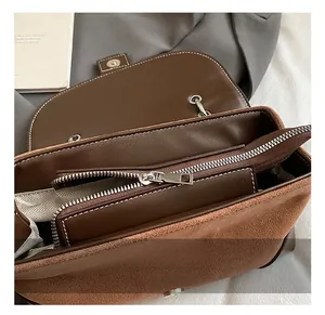 Detail shot of brown shoulder bag with metal zipper and herringbone fabric lining