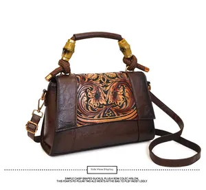 Close-up of vintage leather bag with embossed flowers and unique bamboo handle details
