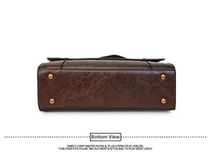 Detailed bottom view of vintage brown leather handbag with four bronze metal feet