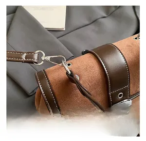 Detail of vintage suede stitching bag with silver rotating hook and contrast stitching
