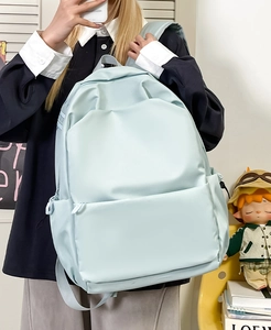 Mirror selfie showing the large light blue nylon backpack being worn by a student