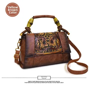 Detailed macro view of the vintage brown leather bag with embossed floral patterns