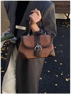 Detail of vintage patchwork handbag featuring suede textures and silver horseshoe buckle