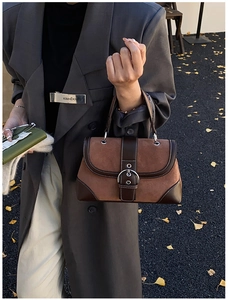 Detail of vintage patchwork handbag featuring brown suede leather and metallic ring buckle