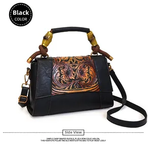 Detail of vintage black handbag with floral embossing and bamboo handle accents
