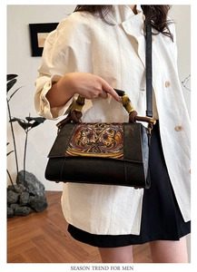 Detailed shot of retro shoulder bag with bamboo handle and floral relief pattern